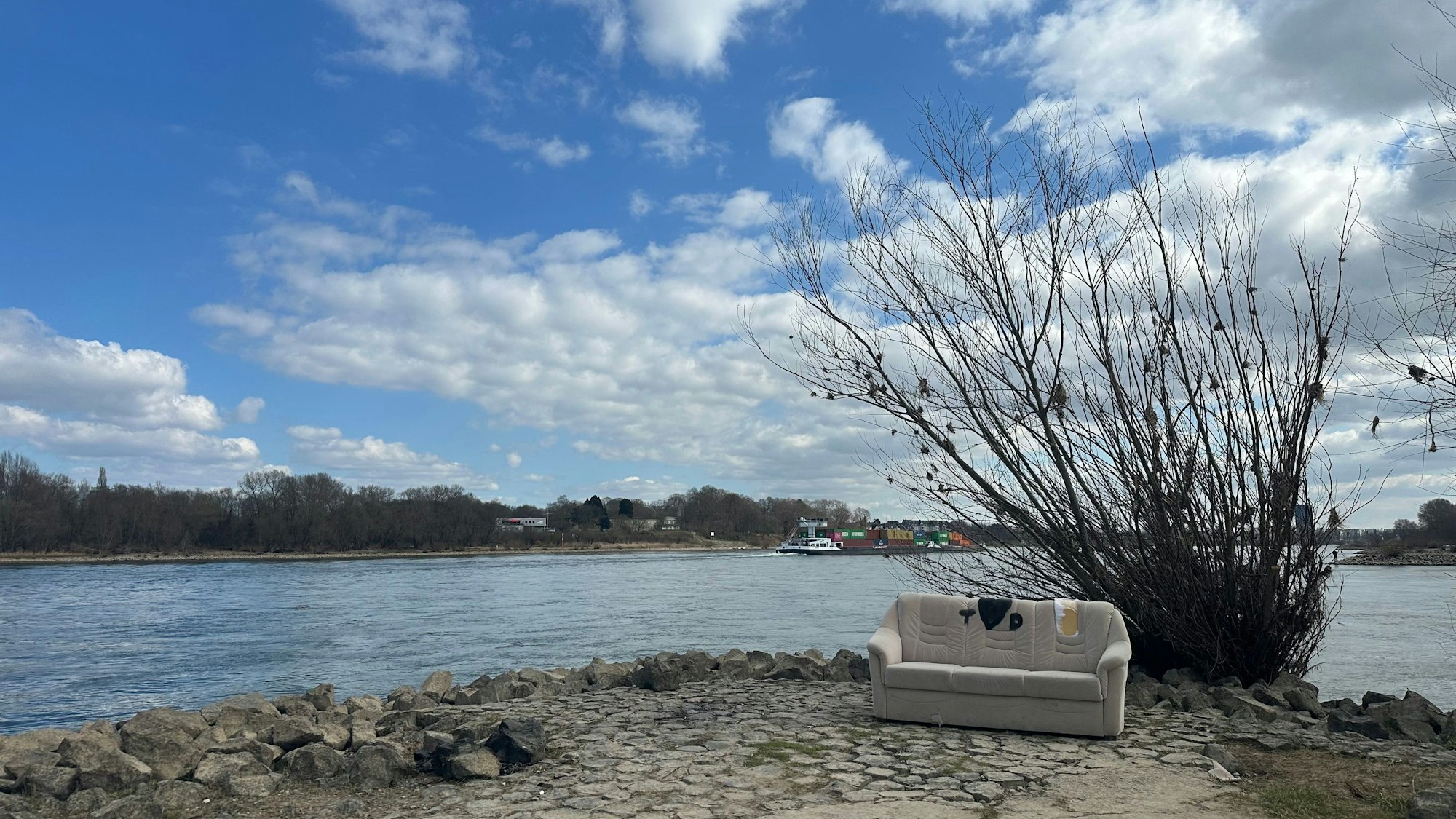 Ein weißes Sofa steht am Rhein.
