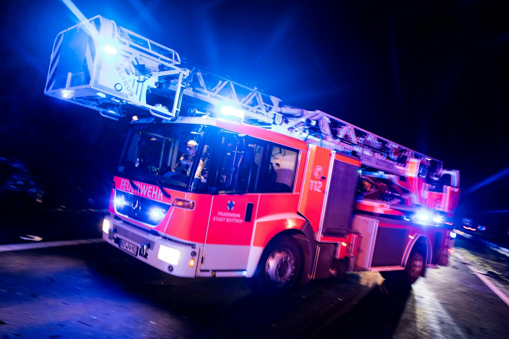 Ein Drehleiterwagen der Feuerwehr fährt mit Blaulicht.